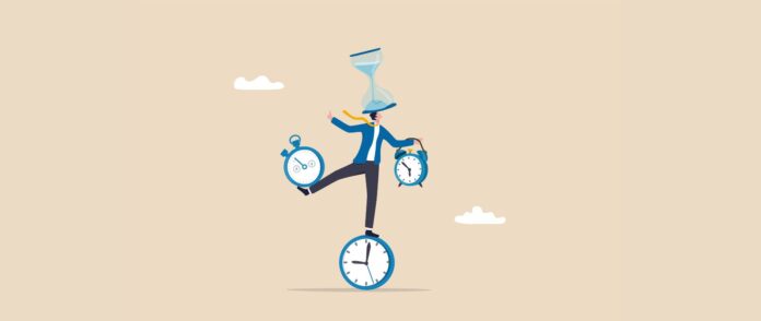 Work-Life-Balance: Ein Mann balanciert auf einer Uhr mit zwei Weckern in den Händen und einer Sanduhr auf dem Kopf.