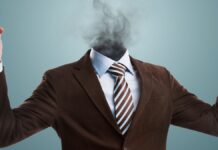 Burnout: Der Kopf eines Mannes im Anzug explodiert.