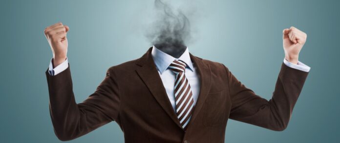 Burnout: Der Kopf eines Mannes im Anzug explodiert.