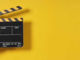 Filmklappe vor gelber Wand