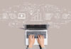 Social Media: Laptop auf grauem Hintergrund, ist im Prozess