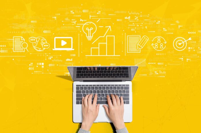 Social Media: Laptop auf gelbem Hintergrund, ist im Prozess