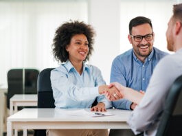 Recruiting: Personalvermittler und seine Klientin schließen ein Bewerbungsgespräch erfolgreich ab.