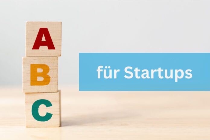 Startups: Die Holzklötze mit dem Buchstaben A,B und C stehen übereinander auf einem Tisch. Daneben steht ein Schriftzug in einem blauen Rechteck 