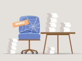 Attraktive/r ArbeitgeberIn: EIn Sessel voller Spinnweben und ein Tisch mit Stapeln von Papieren.