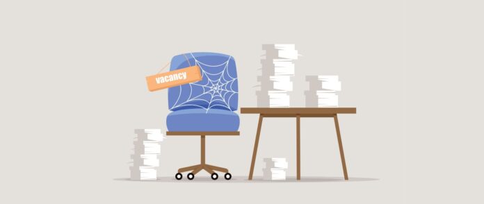 Attraktive/r ArbeitgeberIn: EIn Sessel voller Spinnweben und ein Tisch mit Stapeln von Papieren.