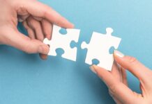 Partnerunternehmen: Zwei Personen verbinden ihr Puzzleteile.