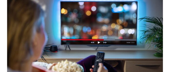 Streaming-Dienst: Eine Frau entspannt sich abends zu Hause und sieht fern.