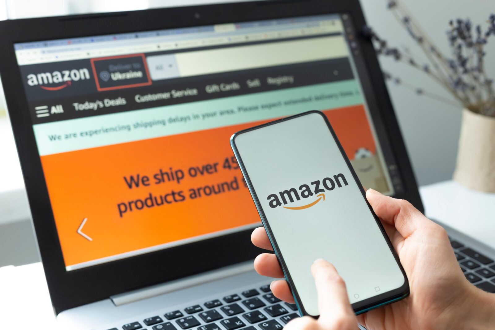 Amazon: Eine Person ist am Laptop und auf dem Smartphone auf Amazon eingeloggt.
