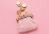 Clever Sparen: Ein rosa Geldbeutel mit Geldscheinen und -münzen.