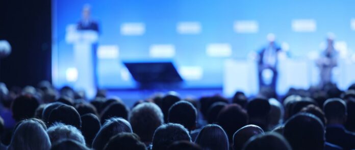 Event-Filme: Ein Mann spricht auf einer Bühne vor einem großen Publikum.