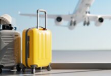 Unbegrenzter Urlaub: Zwei Koffer stehen vor einem Fenster, mit einem Flugzeug im Hintergrund.