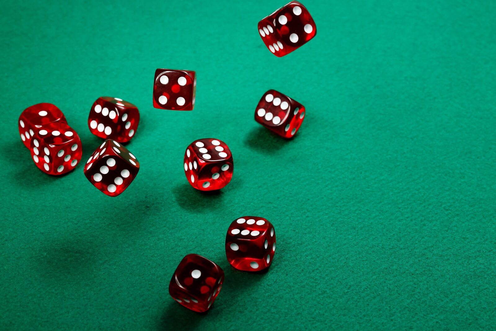 Die Auswirkung von Lizenzvergaben auf das deutsche Online Casino Gewerbe: Rote Würfel rollen über einen Spieltisch
