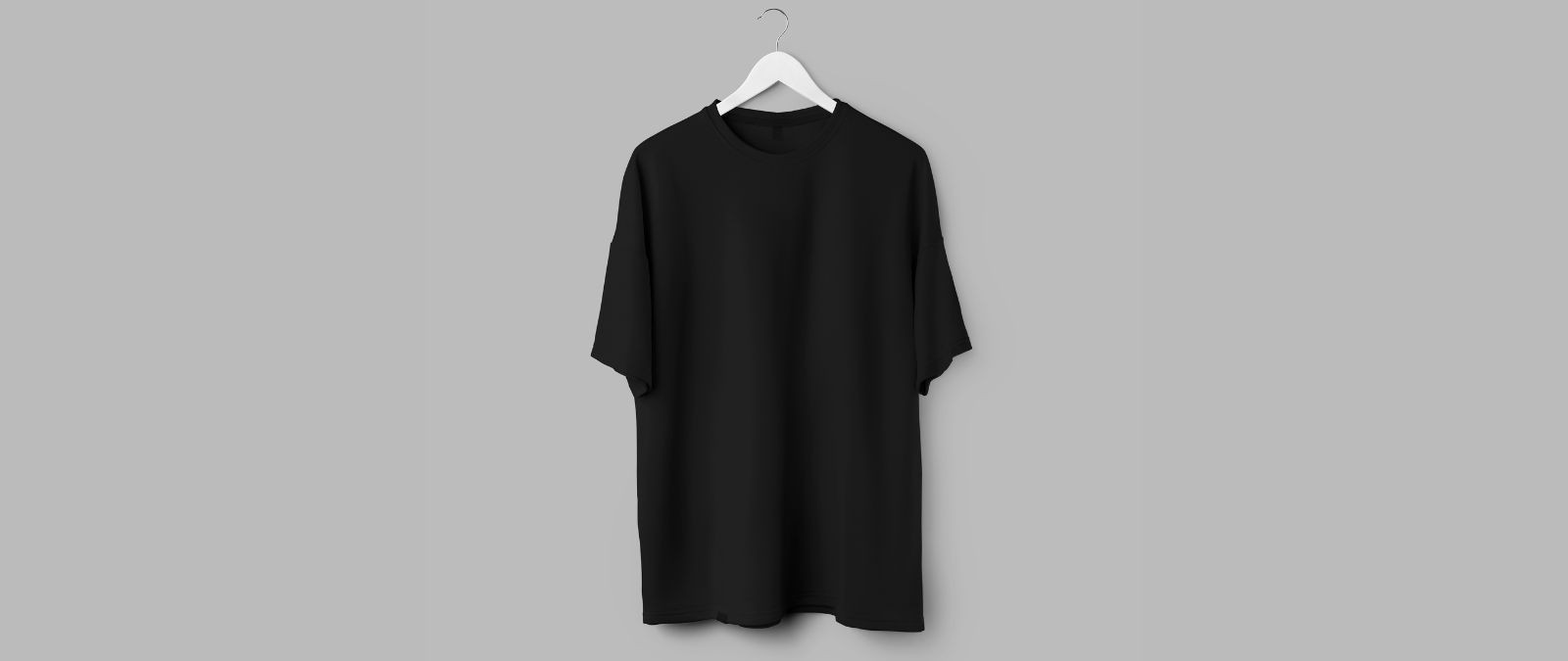 Werbemittel: Ein schwarzes T-Shirt hängt vor einem grauen Hintergrund.
