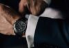 Business-Uhren: Ein Mann im Anzug trägt eine schwarze Uhr.
