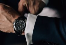 Business-Uhren: Ein Mann im Anzug trägt eine schwarze Uhr.