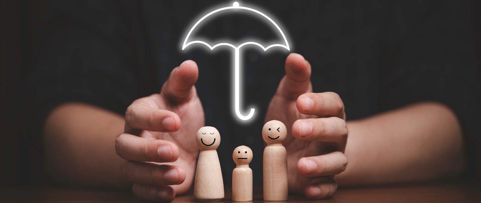 Lebensversicherung kündigen: 3 Figuren werden von zwei Händen und einem leuchtenden Regenschirm geschützt.