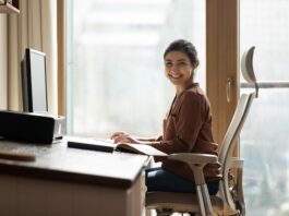Ergonomisch arbeiten: Eine Frau sitzt an einem Schreibtisch.