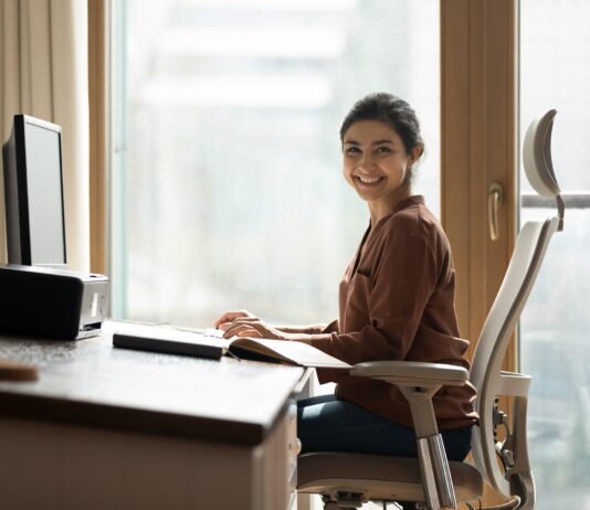 Ergonomisch arbeiten: Eine Frau sitzt an einem Schreibtisch.