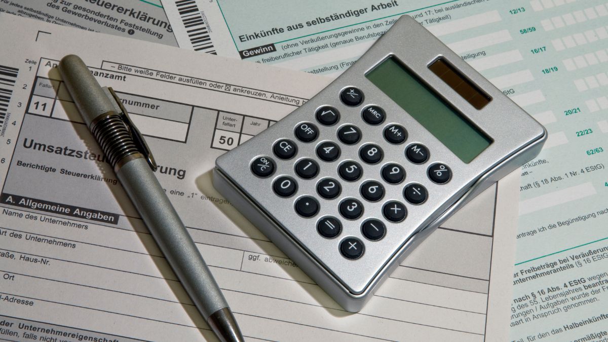Vorsteuerverteilung: Ein Taschenrechner und ein Kugelschreiber liegen auf mehreren Formularen.