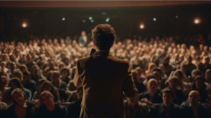 Schauspiel und Kommunikation: Ein Mann hält eine Präsentation vor einem Publikum.