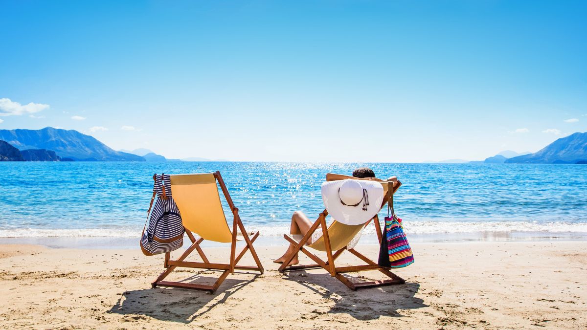Urlaub: Eine Person liegt im Sonnenstuhl am Strand.