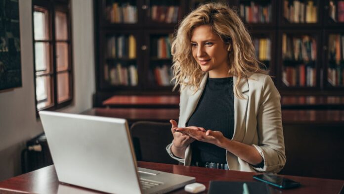 Online coachen: Eine Geschäftsfrau, die einen Laptop für eine Online-Sitzung im Büro benutzt.