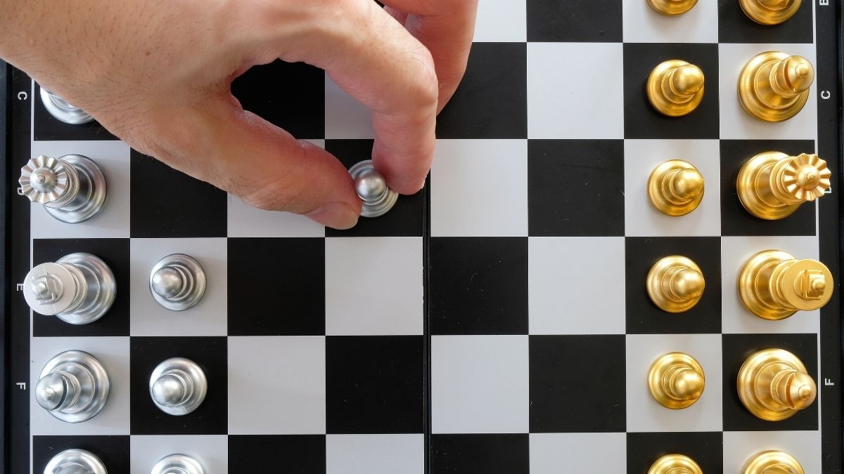 First Mover Advantage: Eine Person spielt den Eröffnungszug zu Beginn einer Schachpartie.