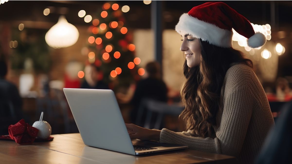 Digitaler Nikolaustag: Eine lächelnde Frau surft mit ihrem Laptop im Internet.
