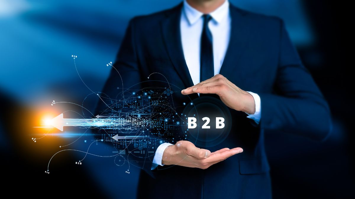 Umsatz im B2B-Geschäft: Ein Mann im Anzug hält den Schriftzug "B2B" in den Händen.