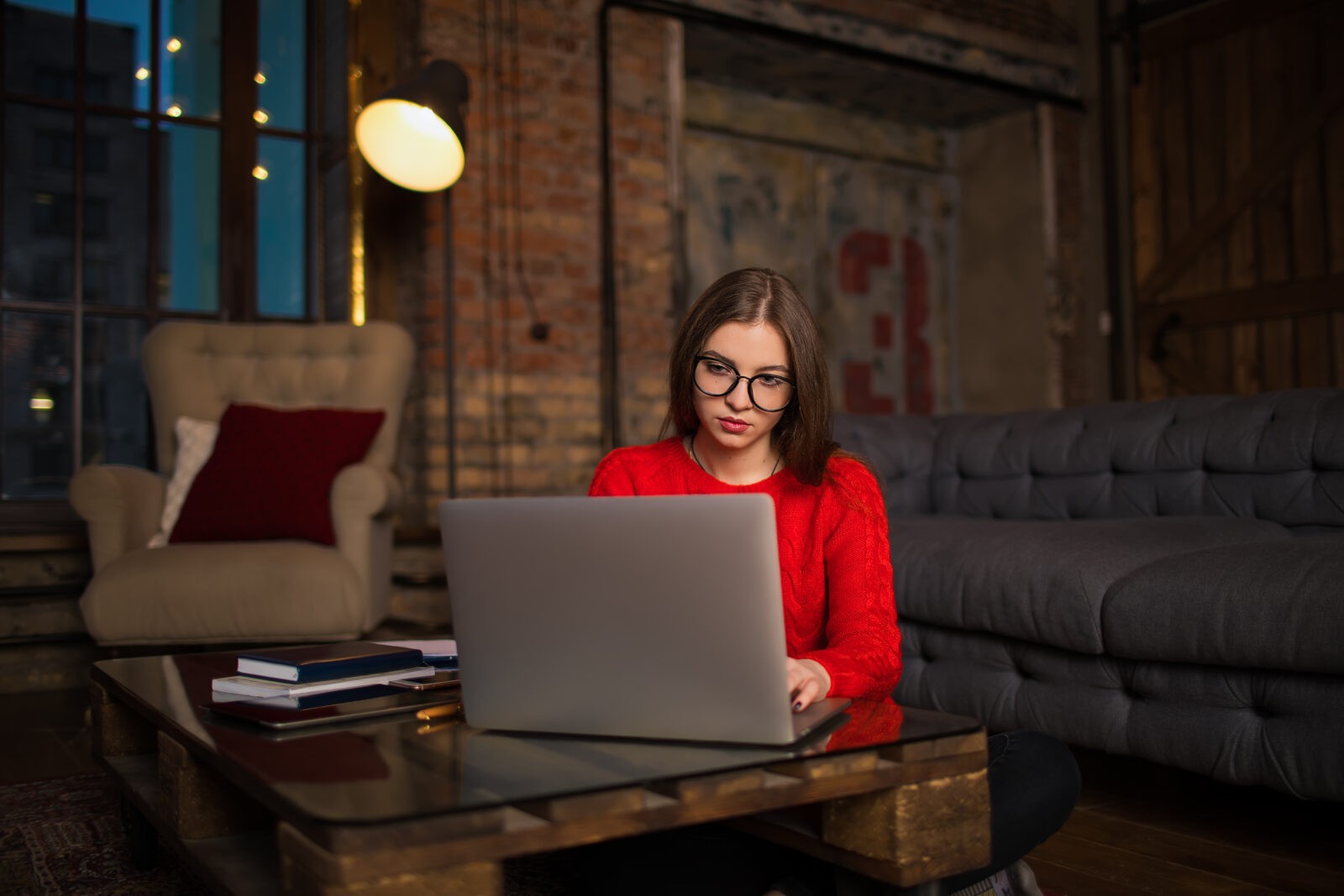 Notebooks: Eine Frau mit rotem Pullover arbeitet an einem Laptop.