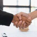 Ein Handschlag zwischen zwei Personen in einem Büro