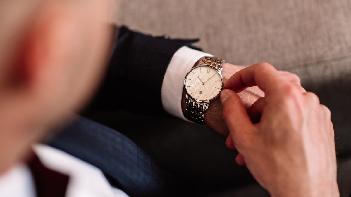 Luxusuhren: Ein Mann im Anzug stellt seine Uhr ein.