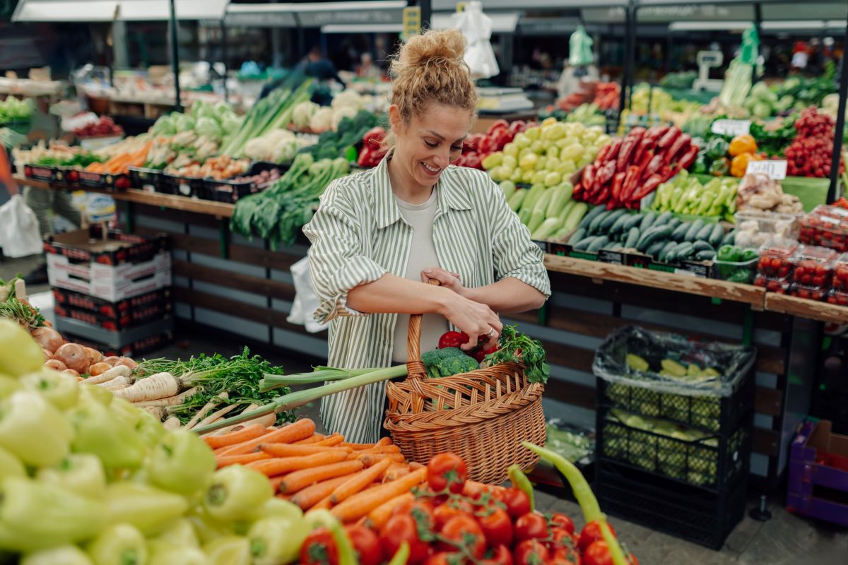 Frau mit Einkaufskrob im Supermarkt, kauft Gemüse ein.